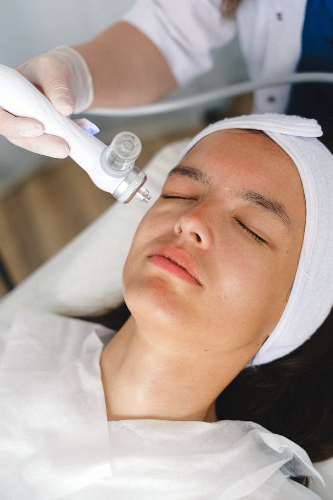 A Skin Care in Hindi Wellhealthorganic client receiving a facial skincare treatment at a spa by a professional beautician using advanced equipment.