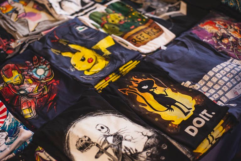 A vibrant Polo Shirts assortment of graphic t-shirts featuring popular characters displayed in a market setting.
