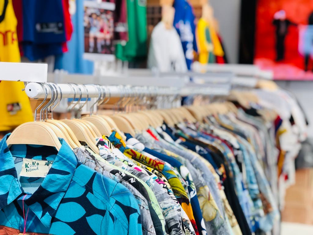 A vibrant collection of Polo Shirts Hawaiian shirts on hangers in a clothing store with varied designs and colors.https://allhiphop.co.uk/wp-content/uploads/2025/09/a-vibrant-collection-of-hawaiian-shirts-on-hangers-in-a-clothing-store-with-varied-designs-and-colors.allhiphop.co.uk