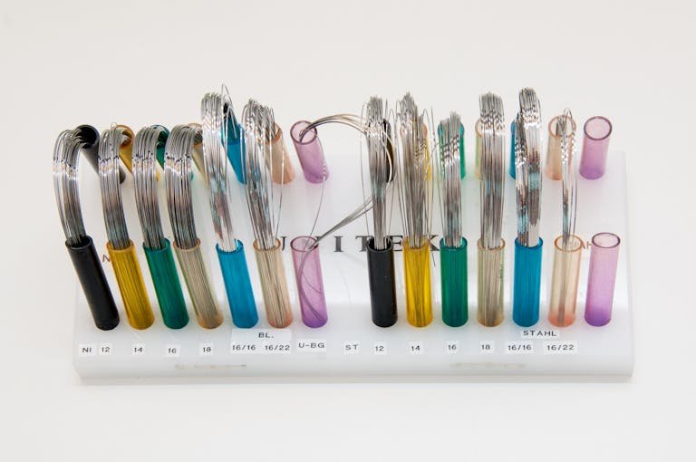 Braces Colors Display of colorful orthodontic wires arranged neatly on a stand.