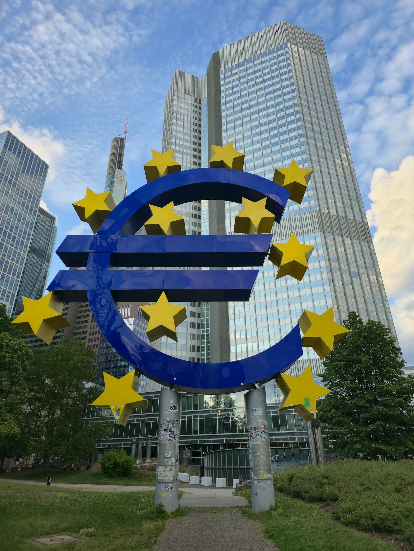 International Banking The Euro sculpture stands tall amid Frankfurt's modern skyscrapers, symbolizing financial strength.