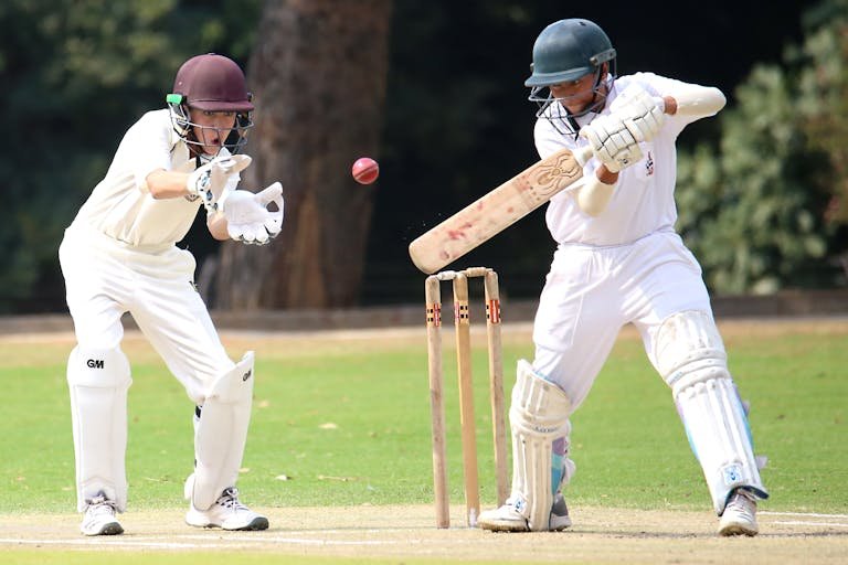 Wheon Cricket 07 Two cricket players in action on a sunny day, showcasing skillful batting and wicket-keeping.