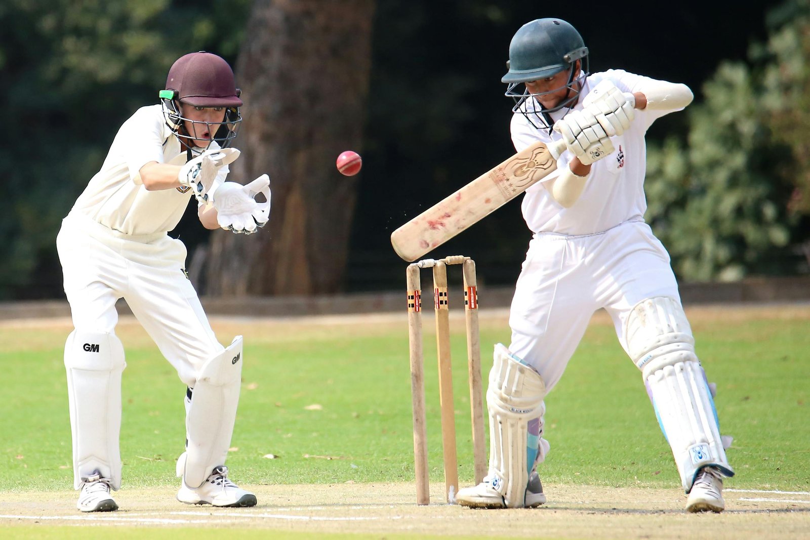 Wheon Cricket 07 Two cricket players in action on a sunny day, showcasing skillful batting and wicket-keeping.