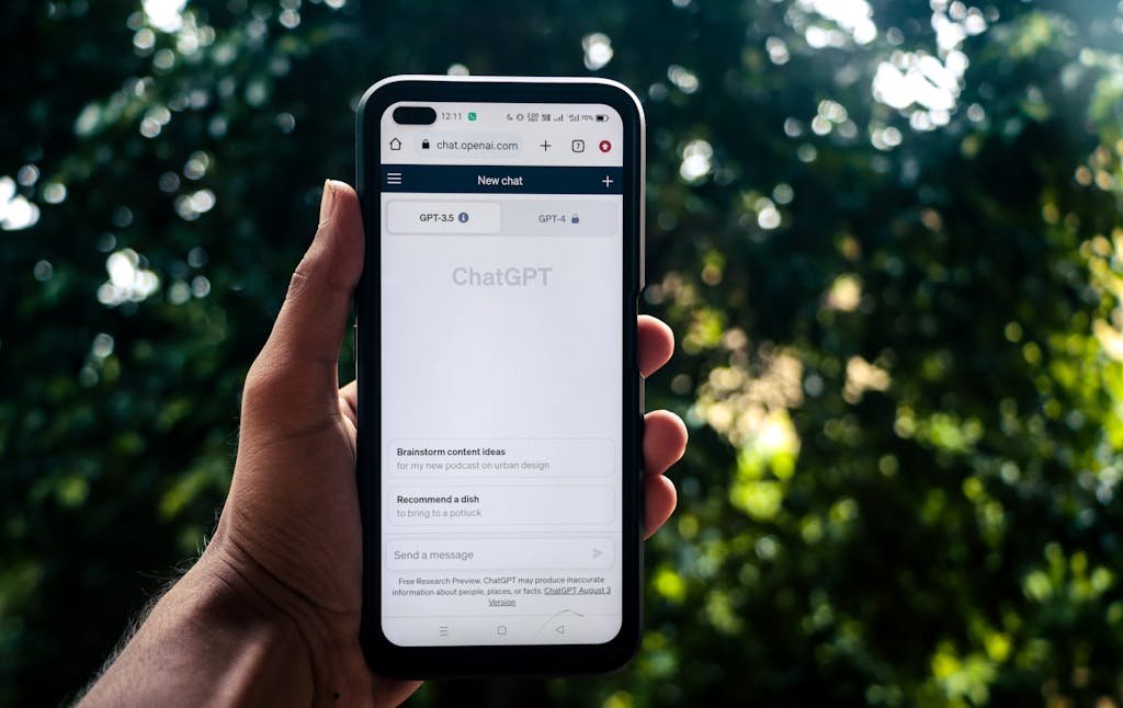 A person uses ChatGPT on a smartphone outdoors, showcasing technology in daily life.Stormuring