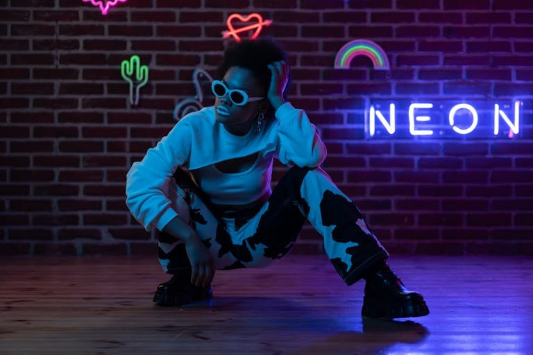 Hip Pop Kombucha Stylish African American woman posing with neon signs and urban vibes.